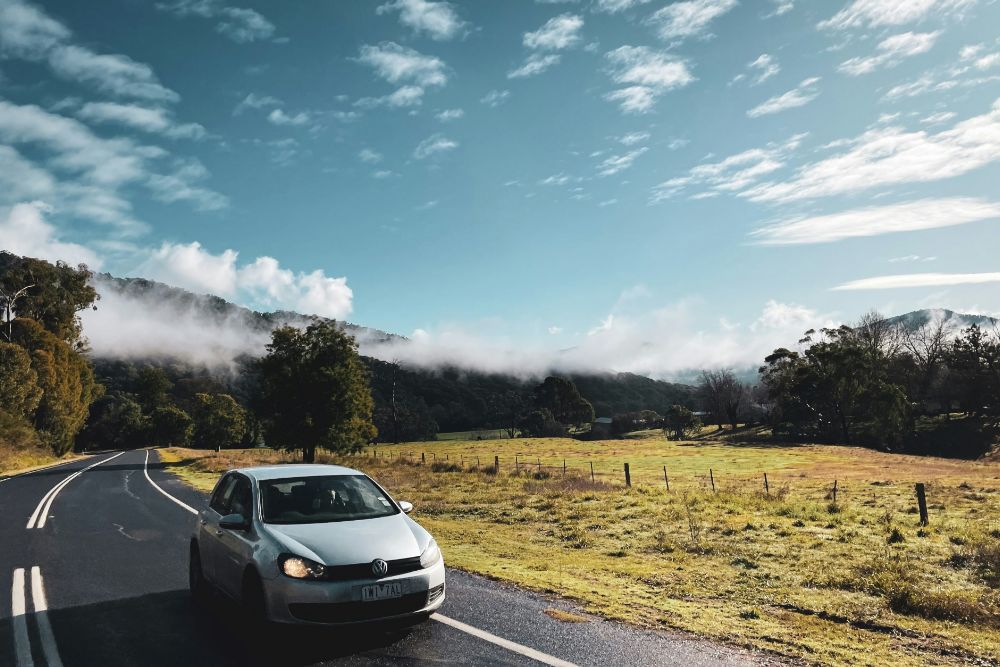 Car driving through the countryside, representing using a vehicle as collateral for a personal loan.