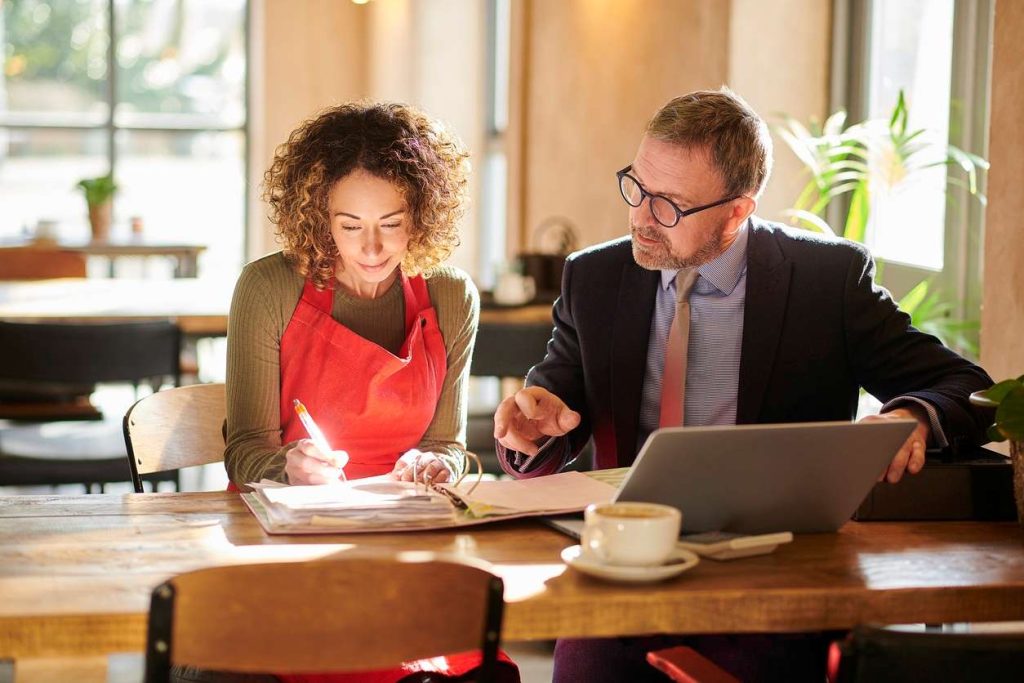 Finance broker advising a business owner on managing a low doc car loan