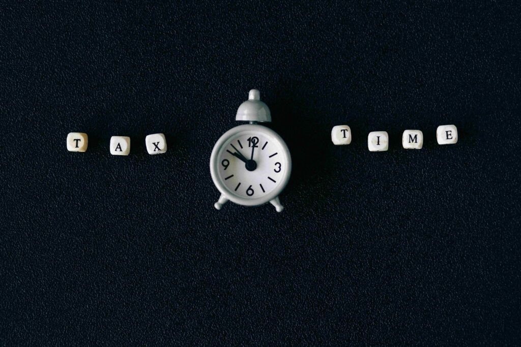 An image of a classic alarm clock set against a black background with the words "Tax Time" prominently displayed. The clock symbolizes urgency and the approaching End of Financial Year deadline, reinforcing the message to take advantage of EOFY tax benefits with low doc finance for upgrading vehicles or equipment.