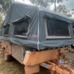 Austrack camper set up on the red dirt at Bramwell Station during Brian’s Cape York adventure.