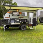 Caravan set up on grass with mountains in the background, representing affordable caravan holidays including caravan finance options.