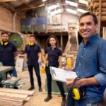 Small business owner working in a wood factory workshop with machinery and timber equipment who may qualify for both the instant asset write-off and equipment finance.