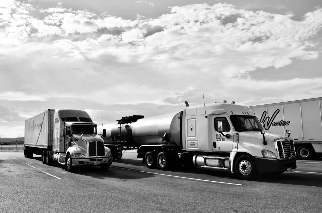 Two commercial trucks parked at a logistics depot, representing EOFY 2026 business finance and asset funding opportunities for Australian businesses.